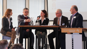 Podiumsdiskussion mit fünf Personen, die an einem Tisch sitzen.