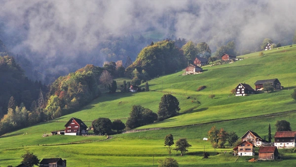 Traditionelle Häuser an einem Hang in den Alpen