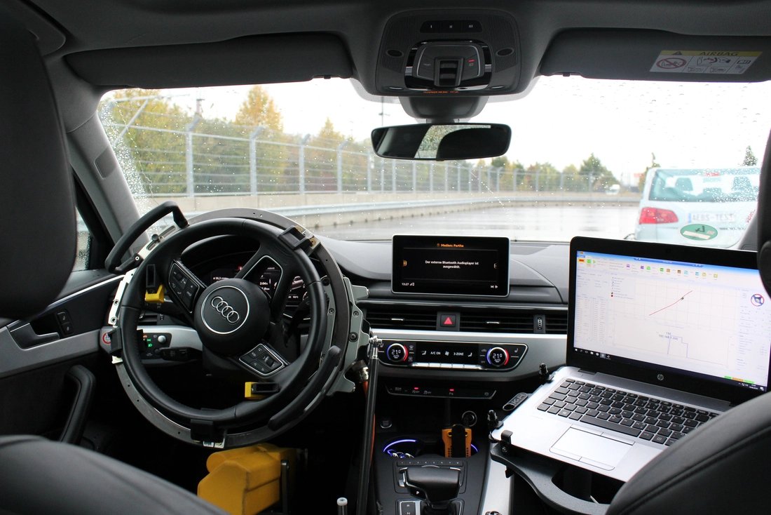 Driving robot controls steering wheel and pedals