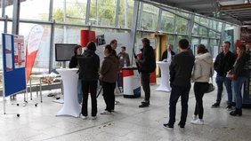 Eine Gruppe von Interessenten am Stand der Business School.