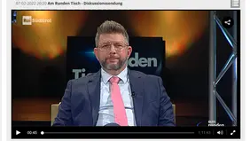 Harry Wagner sitzt im TV-Studio auf einem gelben Sessel