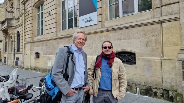 Two men in front of a historical building.